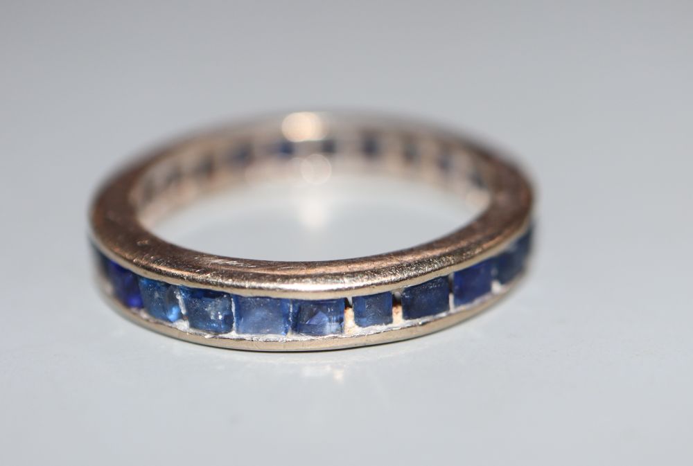 A gilt white metal and sapphire set full eternity ring, size N, gross 3.4 grams.